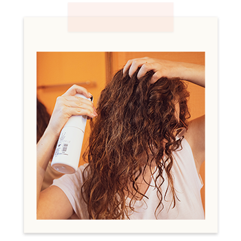 Photo humidifier ses cheveux avec un vaporisateur.